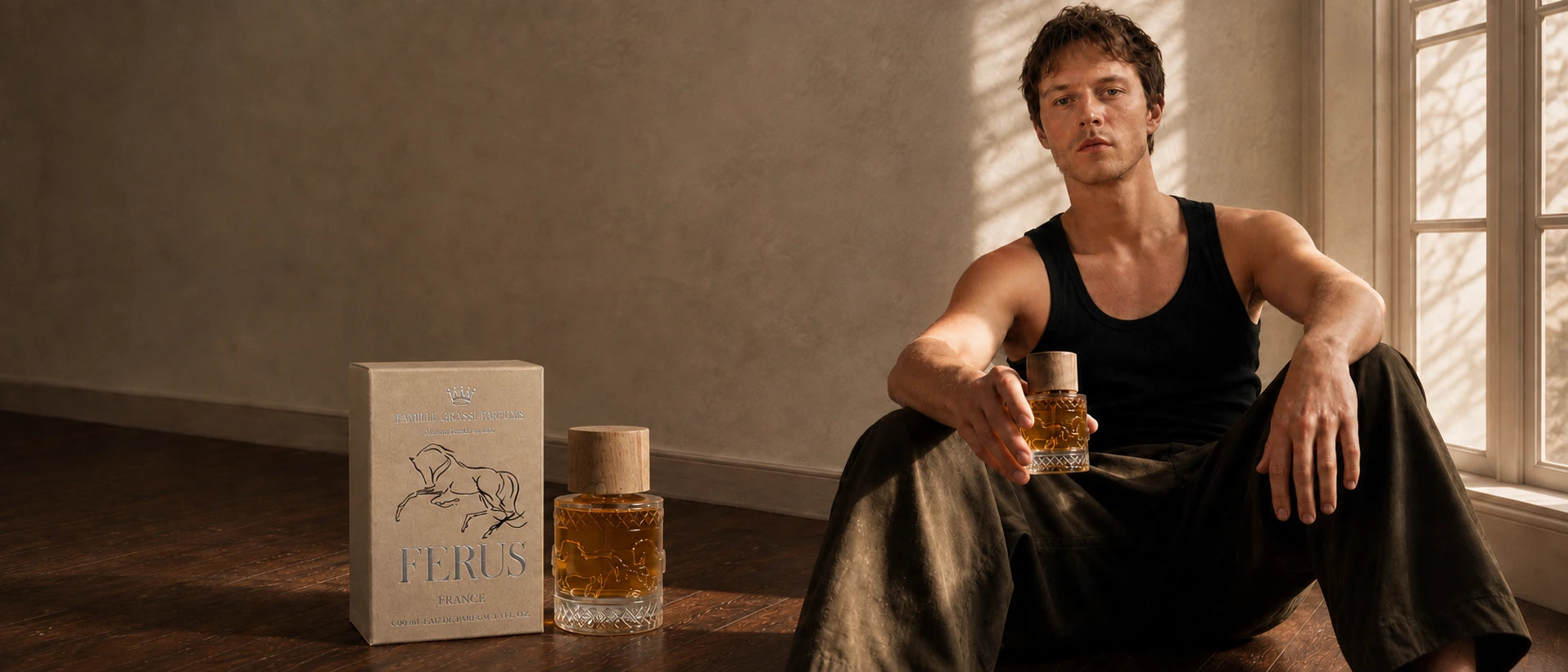 A model holding Ferus perfume in warm window light, with the bottle and its presentation box in the foreground.